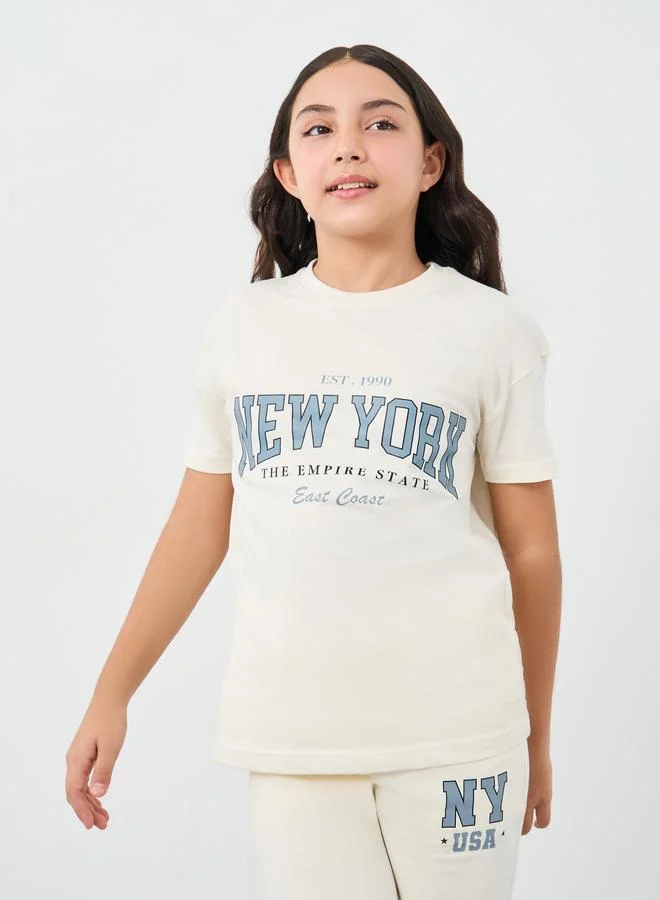 Styli Styli Girls Off White Slogan Print Oversized T-Shirt and Wide Leg Joggers Set