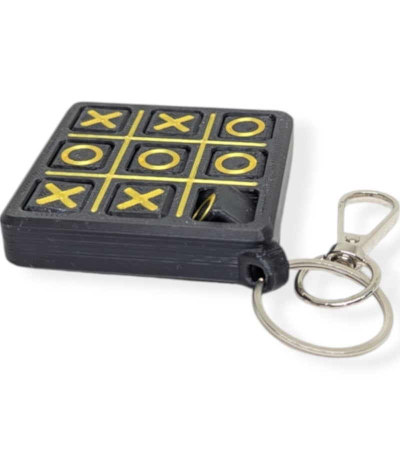 Play XO Keychain – لعبة إكس أو - لعبة ذهنية بسيطة بقطع متحركة  – تعليقة شنطة ومفاتيح – هدية ممتعة لجميع الأعمار – 6×6 سم - Image 1