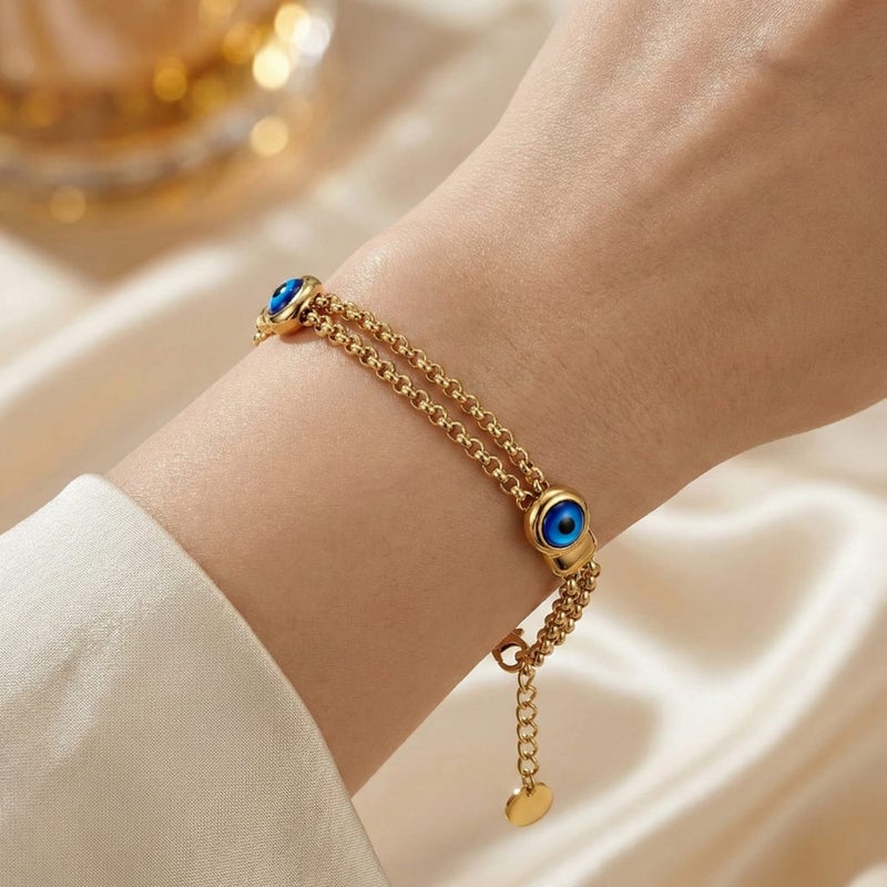 A stylish gold bracelet made of rust-resistant stainless steel, with two interlocking chains and a double "blue eye" design for a modern look, with an adjustable clasp to fit you. - Image 1