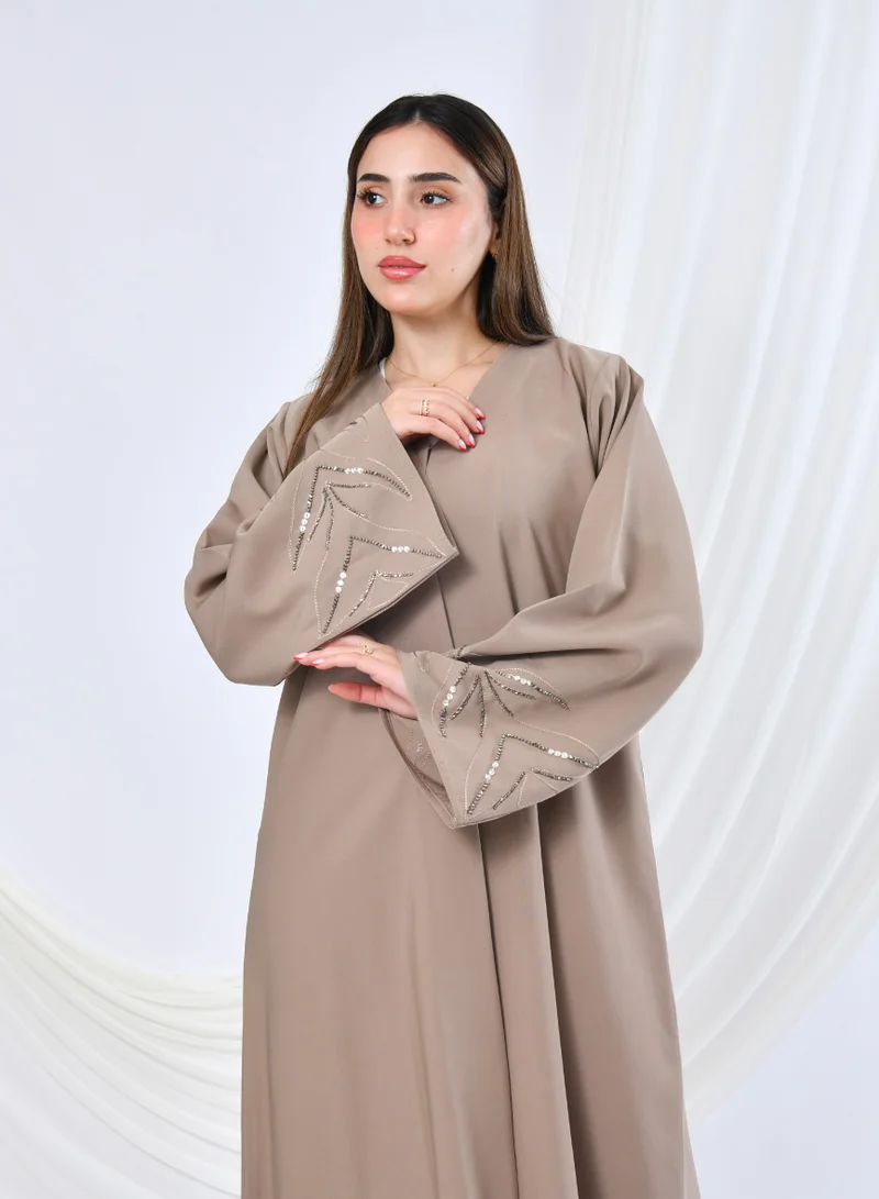 HAWRAA ABAYA Elegant beige abaya with a classic design featuring delicate embroidery and beadwork in a flowy cut.