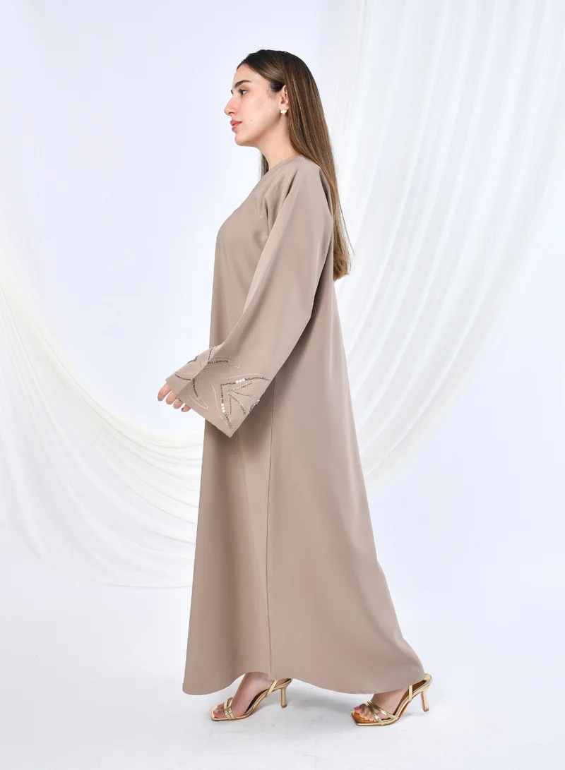 HAWRAA ABAYA Elegant beige abaya with a classic design featuring delicate embroidery and beadwork in a flowy cut.