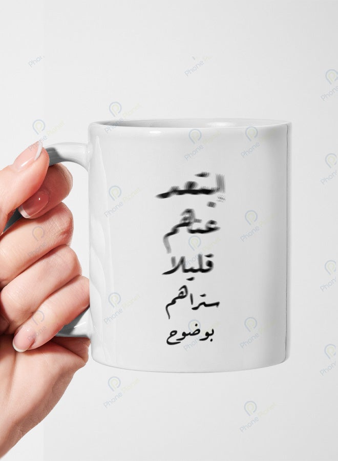 كوب من السيراميك مطبوع عليه عبارة إبتعد عنهم قليلا ستراهم بوضوح ويتميز بمقبض مريح