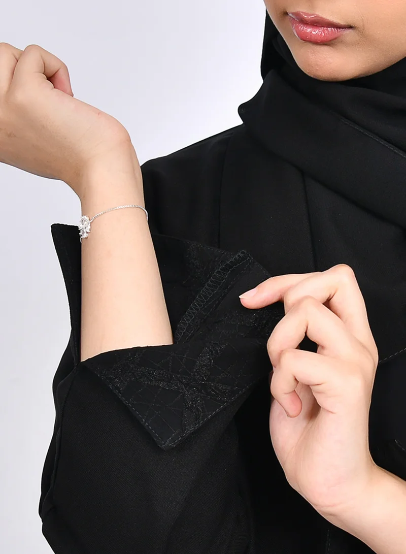 عبايات حوراء عباية بناتيه بقصة ربع كلوش من قماش الكريب وتداخل الجاكار على جانبي العباية بشكل سهمي والاكمام