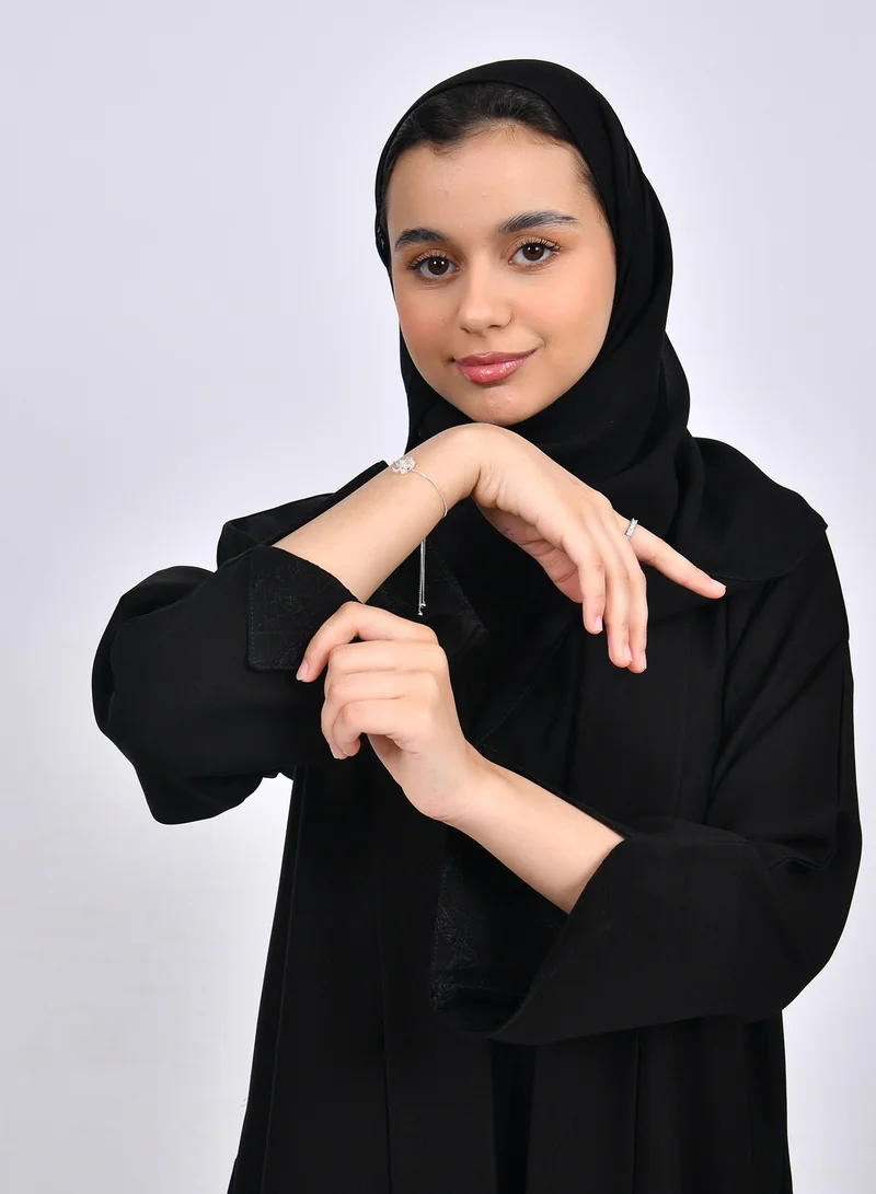 عبايات حوراء عباية بناتيه بقصة ربع كلوش من قماش الكريب وتداخل الجاكار على جانبي العباية بشكل سهمي والاكمام
