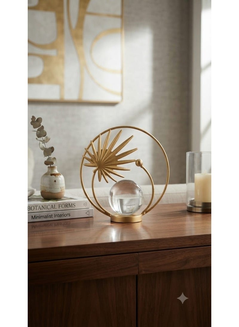 A decorative gold metal ornament with a circular design featuring a leaf and a clear crystal ball - a modern and elegant decoration for tables and shelves. - Image 1