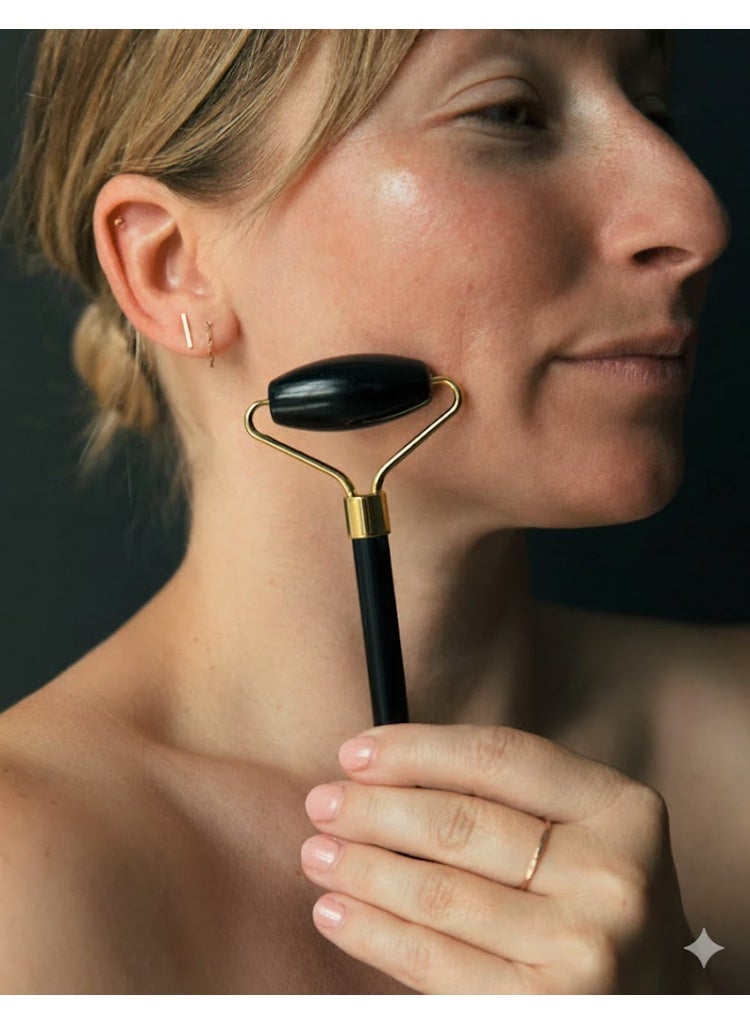 This black double-sided facial massage roller massages and firms the face and neck, reduces puffiness and dark circles, and smooths skin contours. It stimulates collagen production and features a luxurious design with a comfortable grip and double rolling surface for a relaxing and daily skincare experience. - Image 1