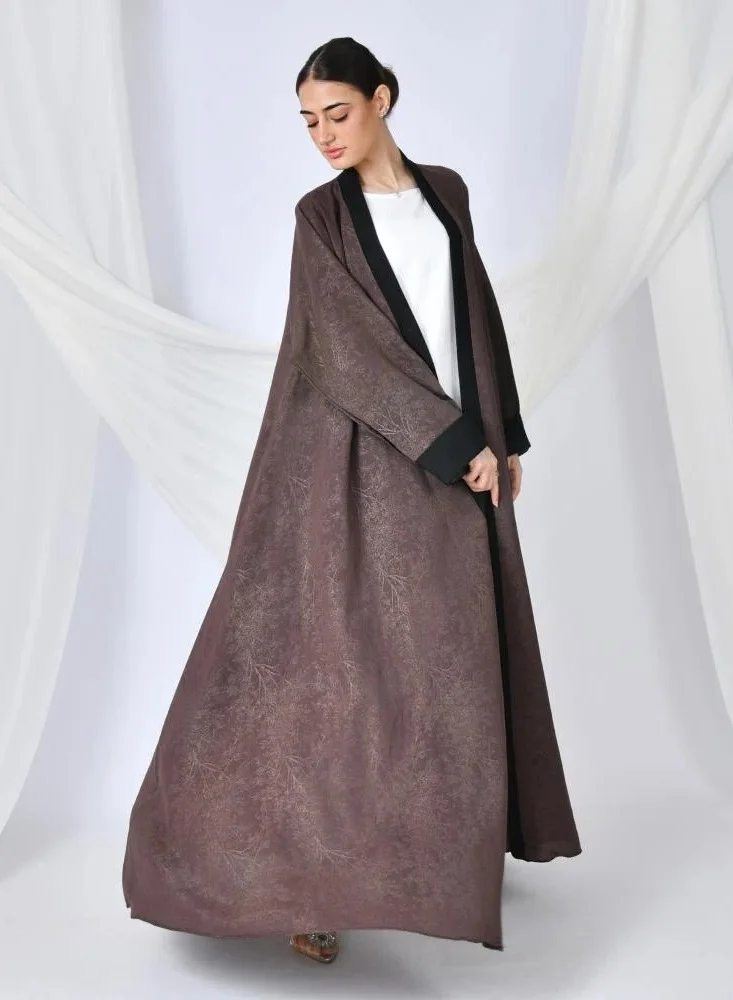 lamha abaya A brown quarter-length wrap abaya with a patterned summer jacquard fabric and black overlay on the sleeves and sides of the abaya.