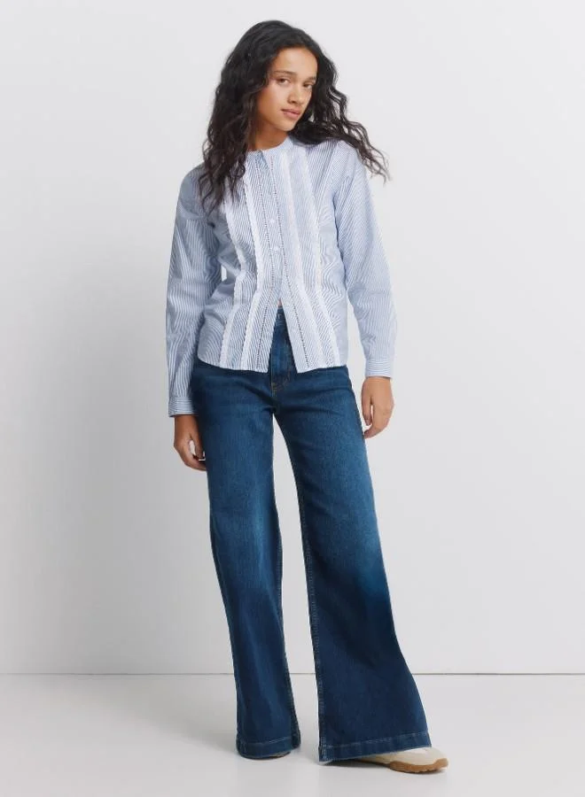 Long sleeve shirt with volume, with mandarin collar, with button fastening, with lace detail on the front and cuffs.