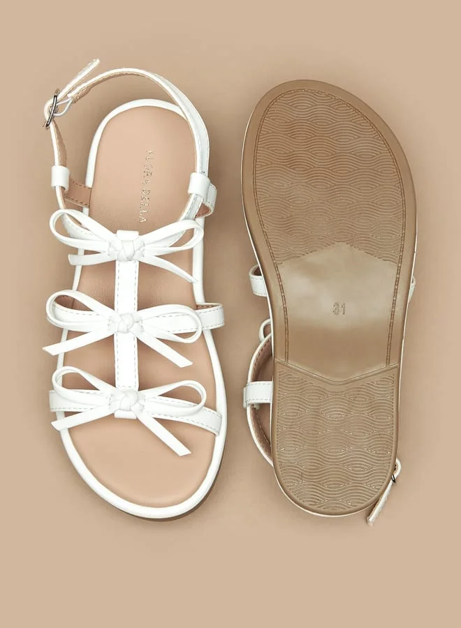 فلورا بيلا من شو إكسبرس Girls Bow Accent Flat Sandals with Buckle Closure