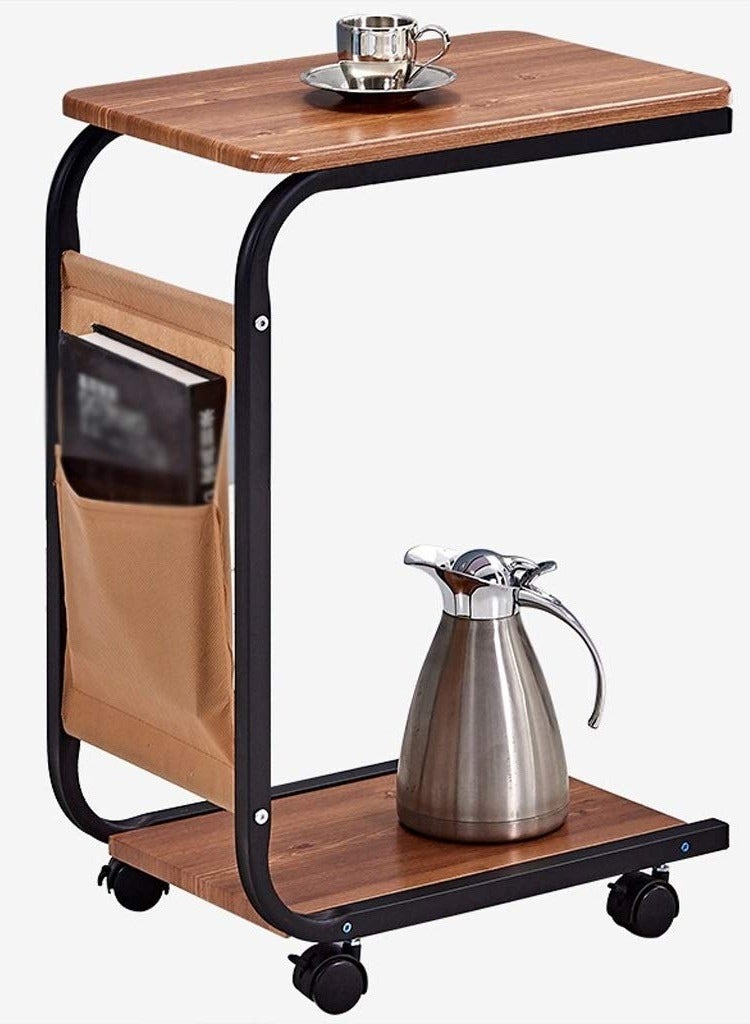 Generic Movable side table with C-shaped wheels, Gemini brown wooden top and durable black metal frame. Multi-functional. Includes a lower shelf for extra storage space and a side pocket for storing bill envelopes, notebooks, magazines or charging cable. Elegant and simple design, space-saving and easy to move thanks to the wheels. Lightweight and fits most decors and blends easily with other furniture. Practical for using a laptop, placing a phone, a coffee cup or TV remote, eating a snack or reading a book. You can place it next to the bed, in the living room, in the office to place a coffee tray or in the kitchen. Can be used as a kitchen cart  - Image 2