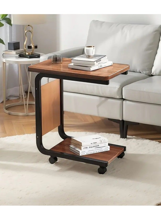 Generic Movable side table with C-shaped wheels, Gemini brown wooden top and durable black metal frame. Multi-functional. Includes a lower shelf for extra storage space and a side pocket for storing bill envelopes, notebooks, magazines or charging cable. Elegant and simple design, space-saving and easy to move thanks to the wheels. Lightweight and fits most decors and blends easily with other furniture. Practical for using a laptop, placing a phone, a coffee cup or TV remote, eating a snack or reading a book. You can place it next to the bed, in the living room, in the office to place a coffee tray or in the kitchen. Can be used as a kitchen cart  - Image 3