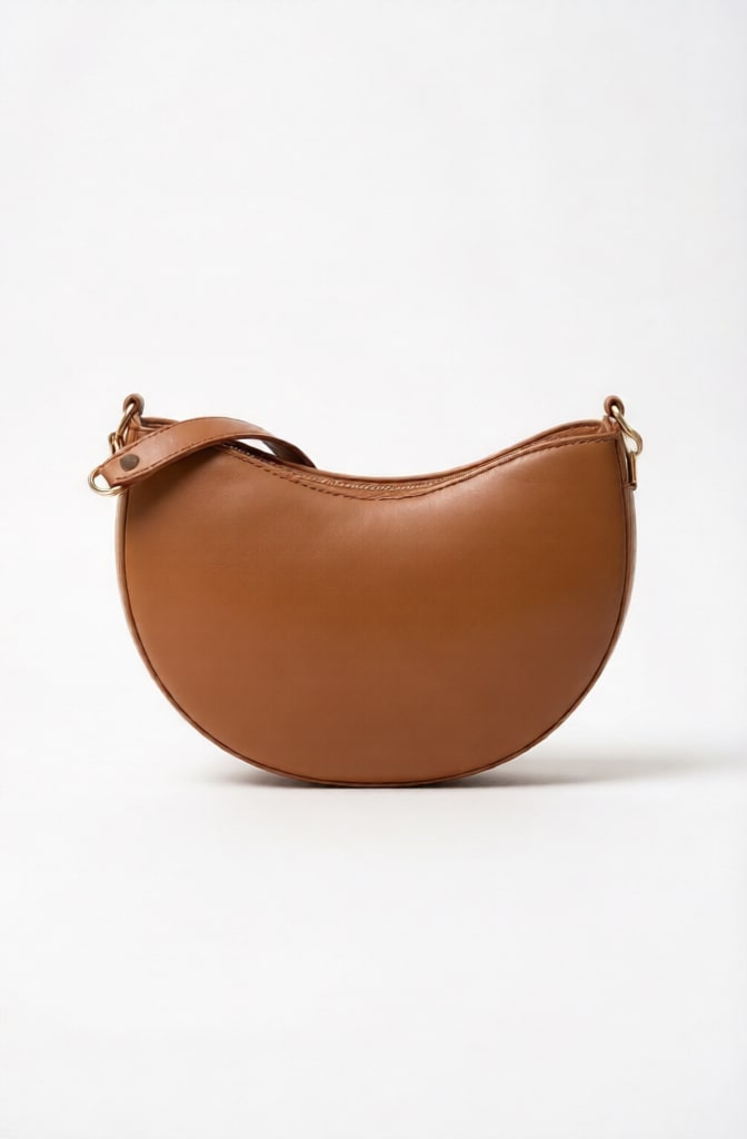 A stylish women's handbag made of genuine leather with a distinctive crescent design, in a camel color, perfect for everyday outings and formal occasions. - Image 1