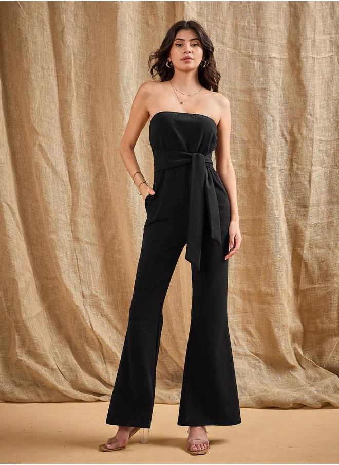 SASSAFRAS Bandeau Neck Belted Flared Jumpsuit