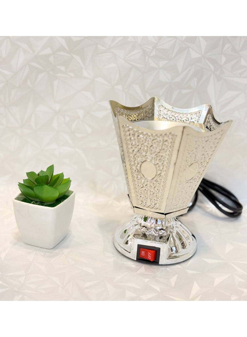 NAMA A Modern And Practical Electric Incense Burner Designed With A Classic Oriental Flair. The Body Is Made Of A Hard Plastic Or Metallic Material With A Complete Polished Silver Or Chrome Finish, Featuring Ornate, Embossed Details Such As Floral Or Traditional Arabic Geometric Patterns On All Sides.