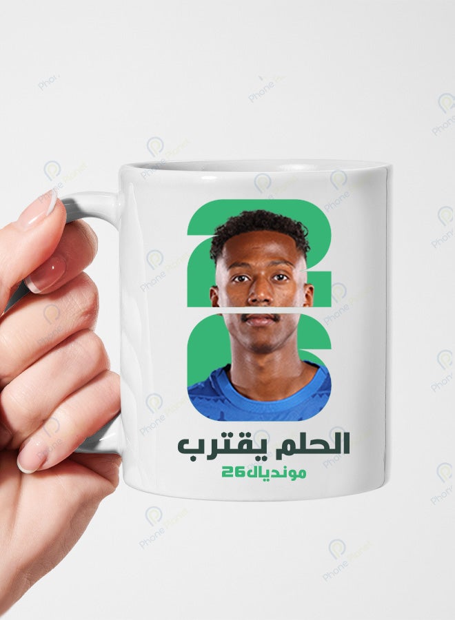 كوب السيراميك الأبيض يحمل تصميمًا لنجم المنتخب السعودي ناصرالدوسري مع عبارة الحلم يقترب ومونديال 2026