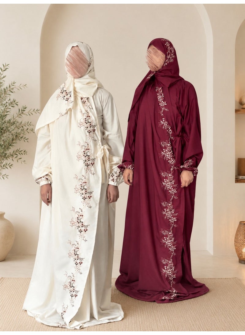 A two-piece women's prayer set featuring elegant embroidery and soft, comfortable fabric; it includes an attached head covering and a loose-fitting design that provides full coverage during prayer.