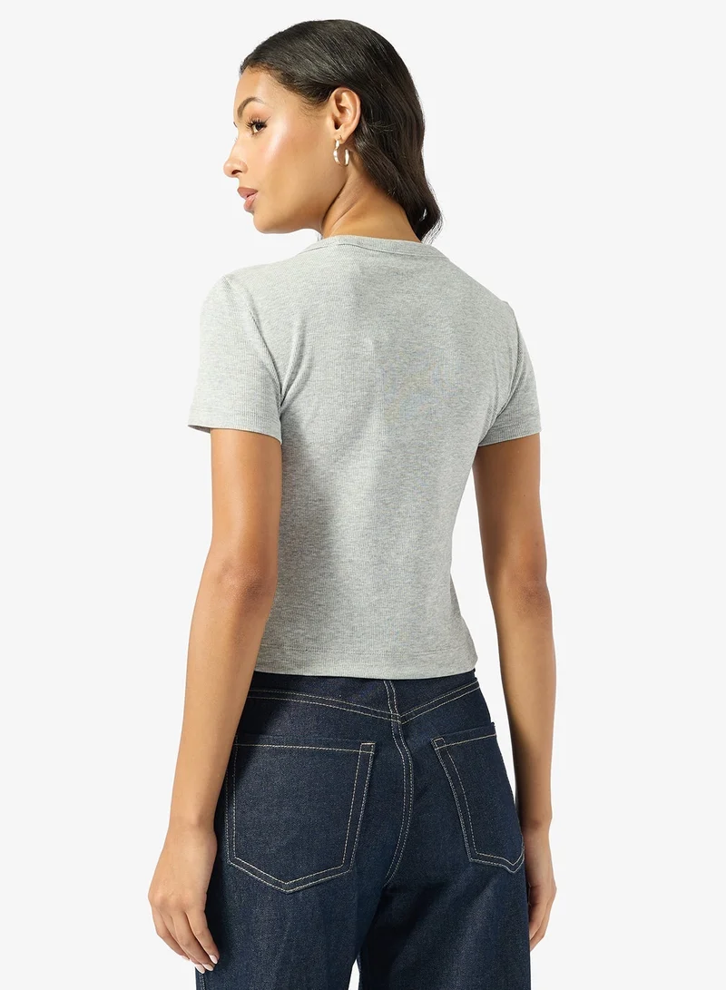 جس تيشيرت بأزرار وياقة دائرية وأكمام قصيرة