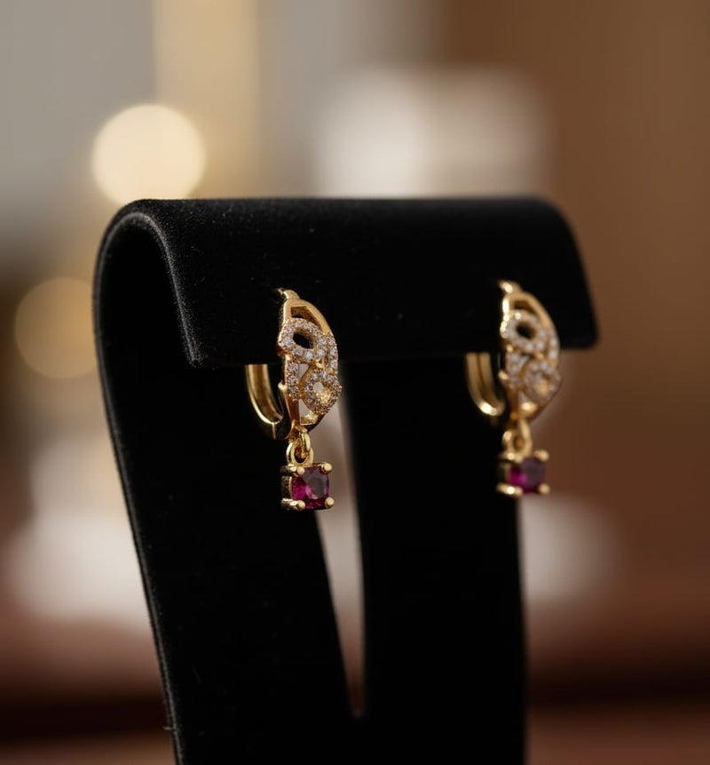 حلق رقيق مطلي باللون الذهبي بتصميم أنيق مرصع بفصوص براقة، يتدلى منه حجر كريم مربع بلون أحمر قرمزي ساحر. - Image 4