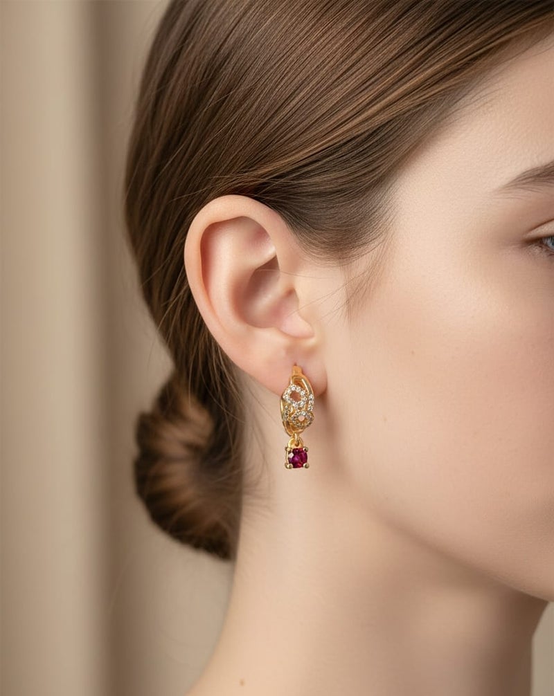 حلق رقيق مطلي باللون الذهبي بتصميم أنيق مرصع بفصوص براقة، يتدلى منه حجر كريم مربع بلون أحمر قرمزي ساحر. - Image 2