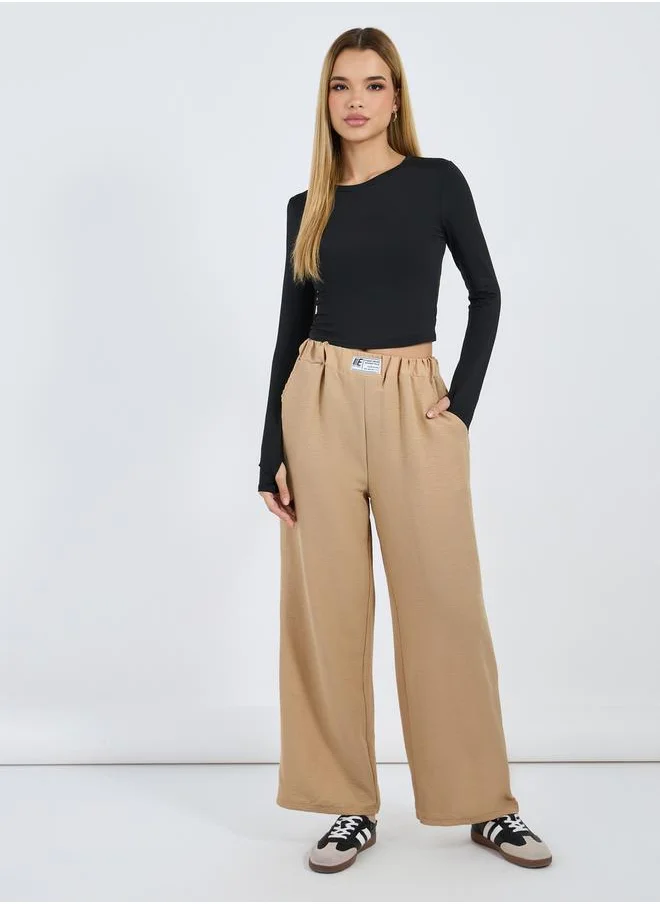 ستايلي Textured Mid Rise Wide Leg Pants with Badge Detail