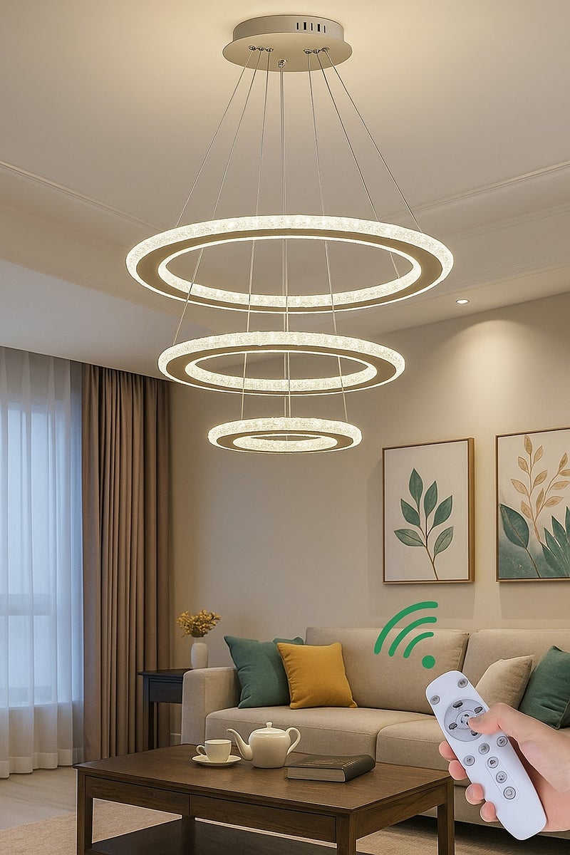 الثريات ثريا بتصميم فاخر وعصري يتكون من حلقات LED دائرية متدرجة،ثريا ب3 ألوان تمنح إضاءة ناعمة ومتوازنة مع لمسة فنية جذابة،مصنوعة من مواد عالية الجودة مع لمسات كرستالية،مثالية لغرفة المعيشة وغرفة الطعام مع ريموت تحكم عن بعد  - Image 1