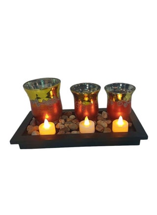 An elegant decorative candle set that adds a warm, luxurious touch to any space. It consists of three glass candle holders in gradient colors of gold and copper with elegant engravings, placed on a black wooden base decorated with natural pebbles for a sophisticated and attractive look. The set contains LED candles that give off a soft and romantic light, making it ideal for decoration in living rooms, bedrooms or dining tables. - pzsku/ZDAB17A8D59F34F071599Z/45/_/1740235540/c840ea7a-fbfe-416d-b7b2-671e8ae6d94c