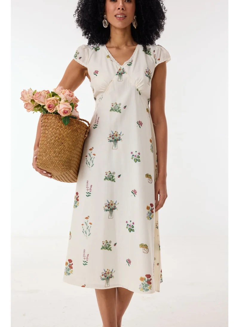 أشيتا فرنانديز فستان ميدي بطبعة زهور وياقة على شكل حرف  وأكمام كاب – عاجي