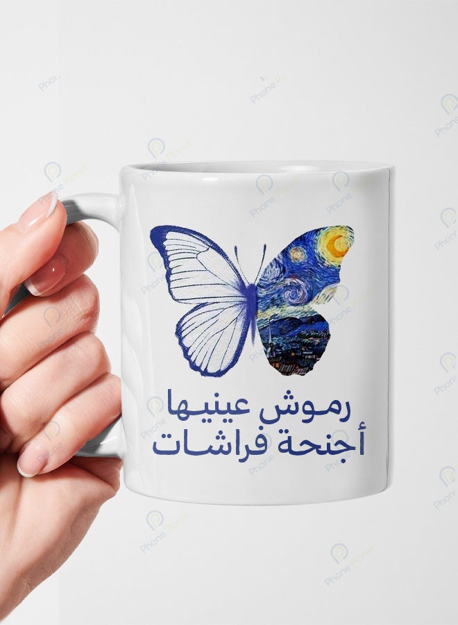 كوب من السيراميك مطبوع عليه عبارة رموش عينيها أجنحة فراشات ويتميز بمقبض مريح
