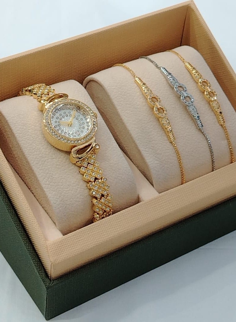 A luxurious and elegant set consisting of a shiny gold watch with three bracelets.