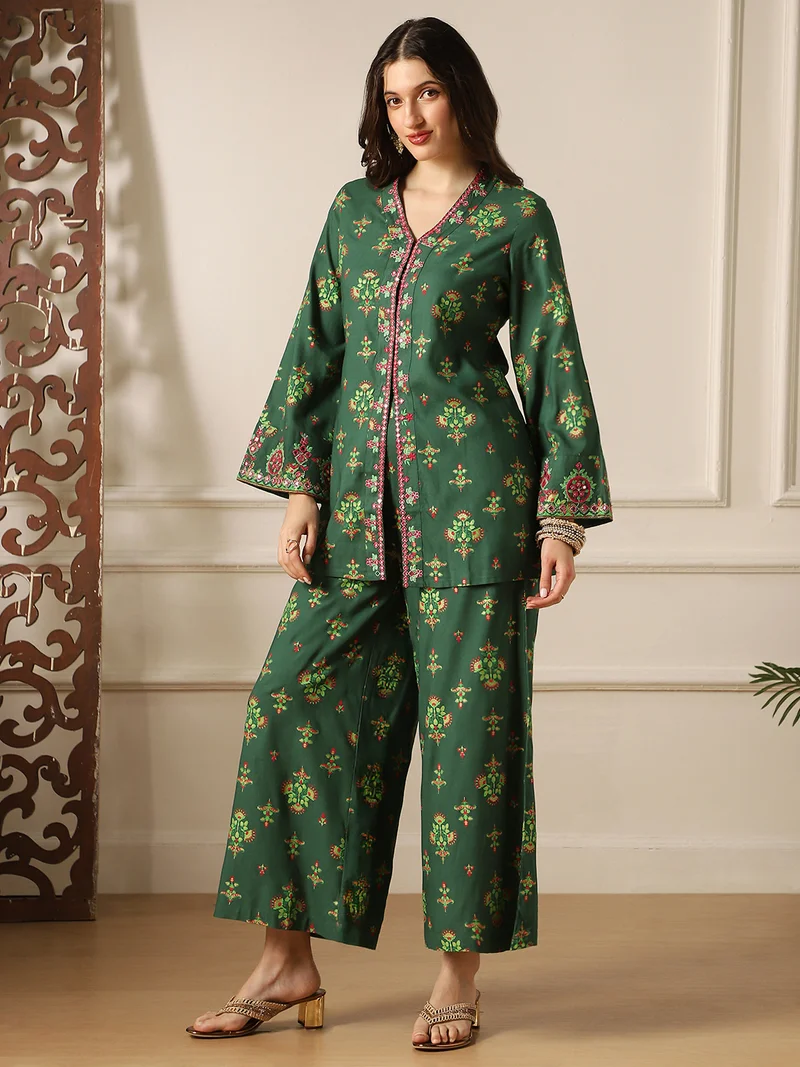 جلو باص طقم نسائي بلوزة وبنطلون بتفاصيل مطرزة باللون الأخضر وزخارف عرقية وأكمام الجرس وفتحة أمامية بتطريز مرآة