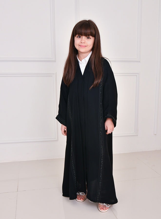 HAWRAA ABAYA Black girls’ abaya featuring long vertical embellishments, designed with a snap-button closure - Image 3