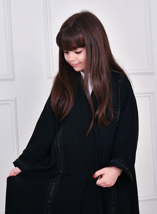 HAWRAA ABAYA Black girls’ abaya featuring long vertical embellishments, designed with a snap-button closure - Image 5