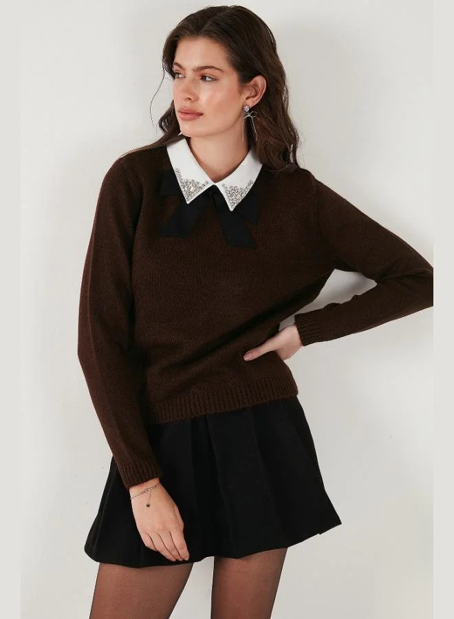 ليلا كنزة نسائية من ليلا بقصة عادية وياقة قميص، ناعمة الملمس مع تفاصيل فيونكة وأحجار الراين