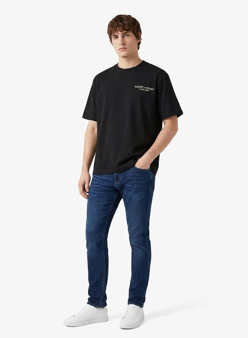 لاكوست تيشيرت كلاسيك بطبعة خلفية وتفاصيل مطرزة