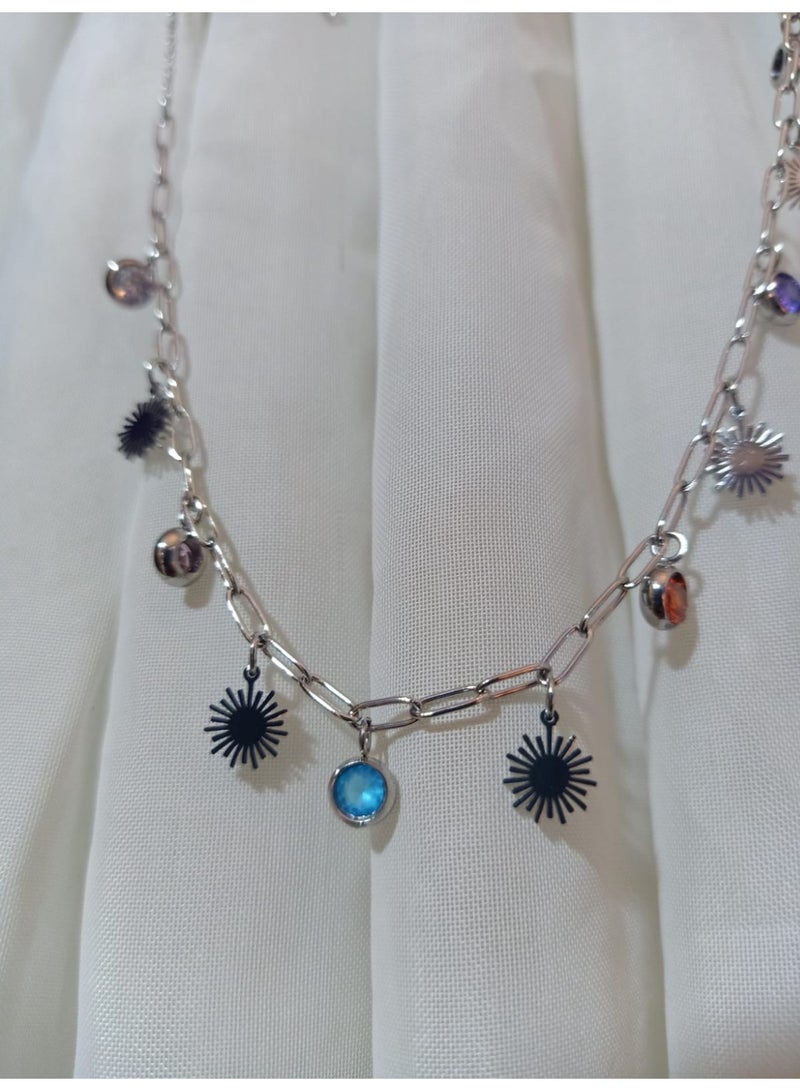 Luxuria A striking silver necklace adorned with flower-shaped pendants and colorful crystals. The necklace features a paperclip chain and various colored pendants, giving it a modern and playful touch. - Image 3