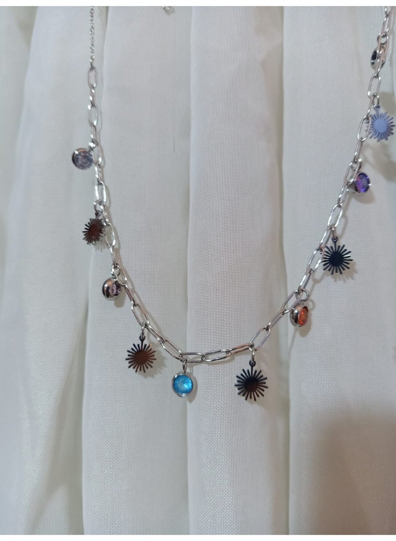 Luxuria A striking silver necklace adorned with flower-shaped pendants and colorful crystals. The necklace features a paperclip chain and various colored pendants, giving it a modern and playful touch. - Image 4