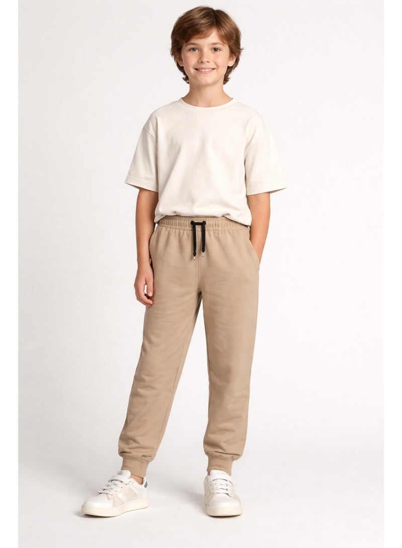شي إن بنطلون جوجر أطفال لون بيج مناسب للبنات والأولاد، بخصر استك ورباط لراحة وثبات أفضل، خامة ناعمة ومريحة، مثالي للبس اليومي والخروج والكاجوال. - Image 1