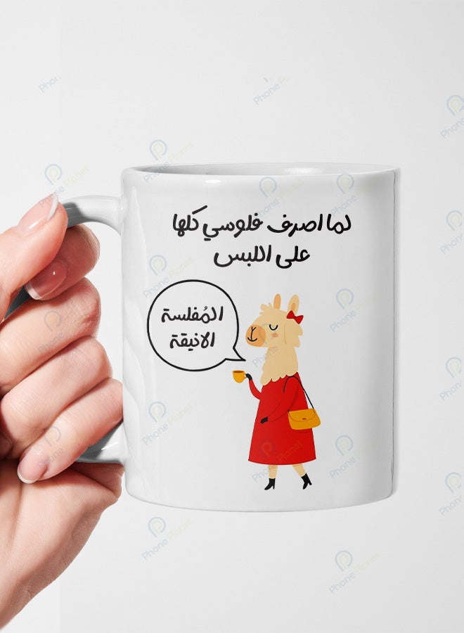 كوب من السيراميك مطبوع عليه عبارة لما اصرف فلوسي كلها على اللبس ويتميز بمقبض مريح