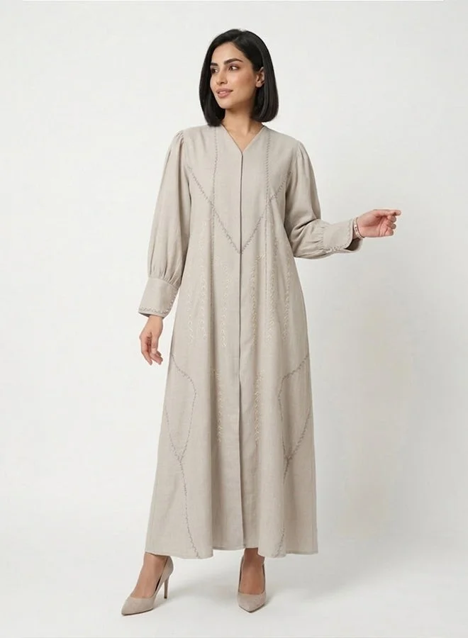 HAWRAA ABAYA Beige closed abaya with snap-button closure, adorned with delicate embroidery and subtle embellishments