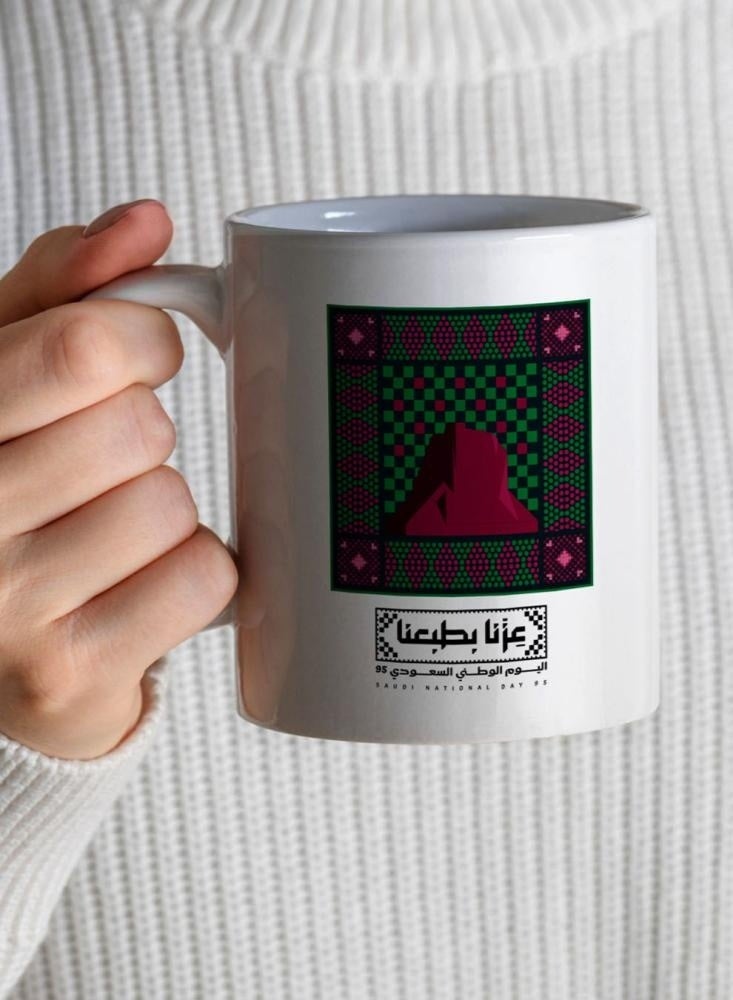 حكاية شمعة اليوم الوطني ، مج من السيراميك بطبعة تصميم "عزنا بطبعنا" بلون أبيض - Image 1