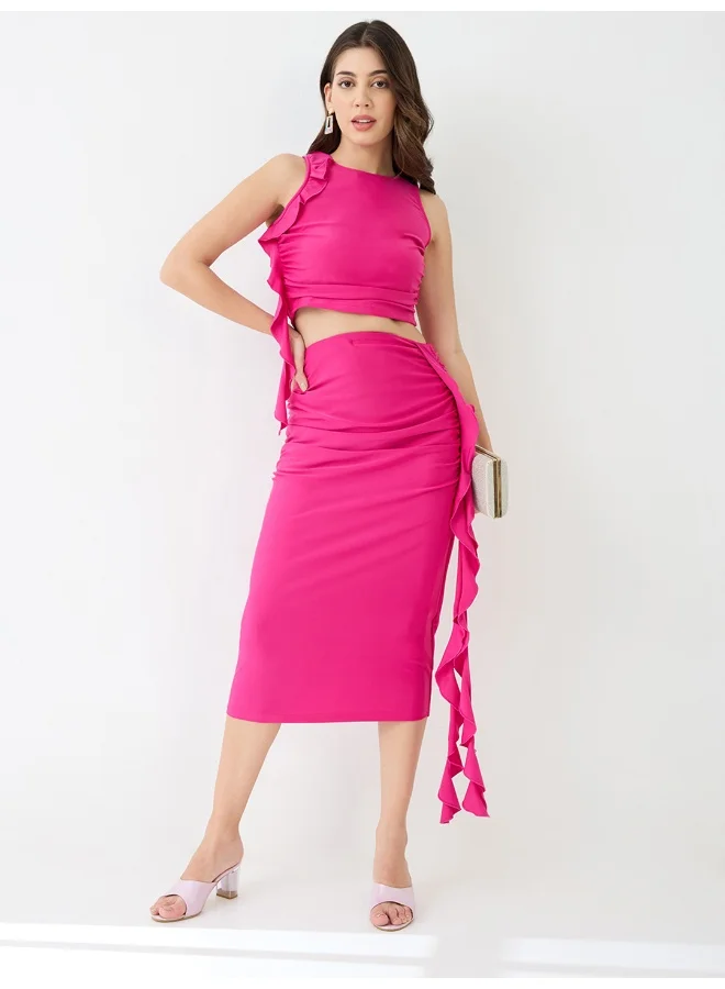 جلو باص طقم نسائي بلوزة قصيرة وتنورة ميدي بتفاصيل كشكش ورقبة دائرية من جلوبس