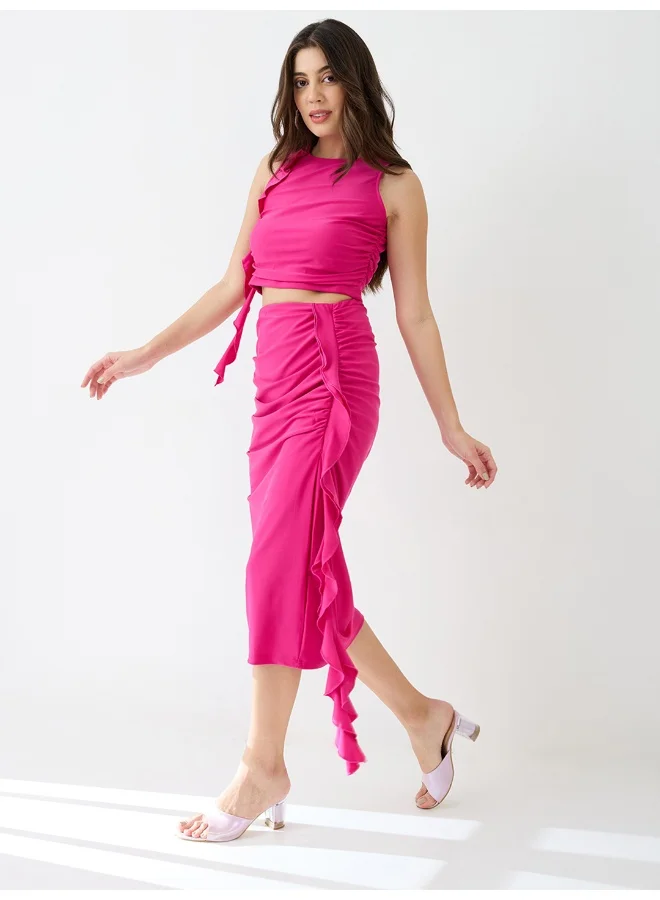 جلو باص طقم نسائي بلوزة قصيرة وتنورة ميدي بتفاصيل كشكش ورقبة دائرية من جلوبس