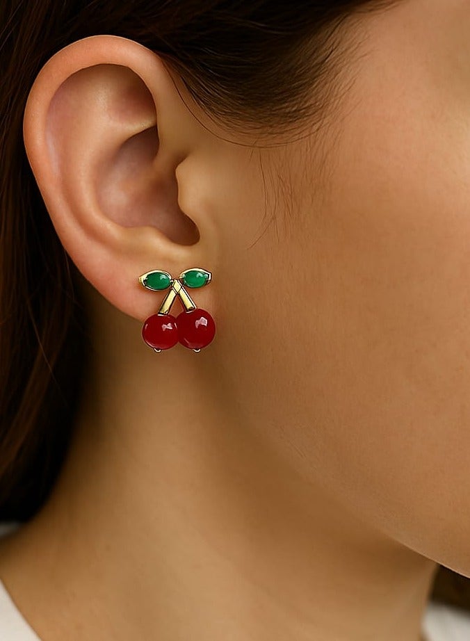 "A playful, feminine touch - made of stainless steel. Add a fresh, playful touch to your look with this cherry earring. Its unique design combines two rich red beads with an elegant gold stem, punctuated by tiny green leaves, adding a charming, natural touch. Perfect for those who love subtle details and unconventional, distinctive looks." - Image 4