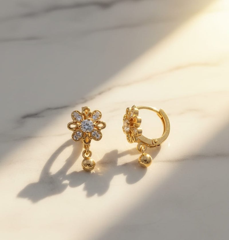A delicate gold-plated earring featuring a sparkling flower design with dazzling stones that add elegance and radiance, completed with a small gold ball-shaped pendant. - Image 3