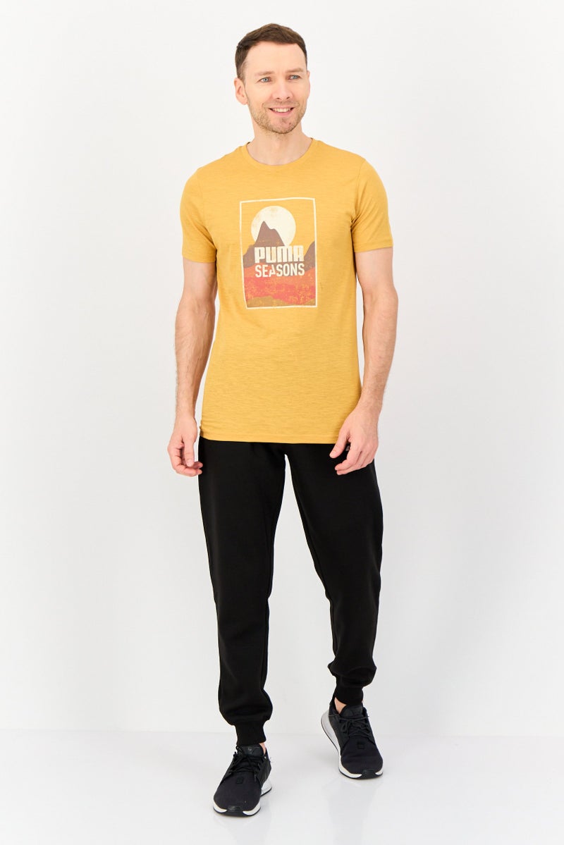 PUMA Men Sportswear Fit Short Sleeve Graphic Print Outdoor T-Shirt, Mustard - Image 2