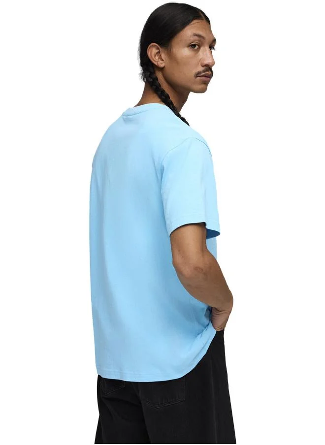 بوما تيشرت Essentials واسع ومزين بشعار PUMA Cat المطوّر للرجال