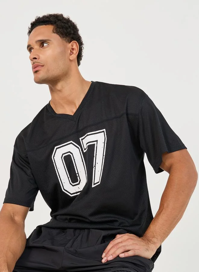 ستايلي اكتيف تيشيرت فضفاض بطبعة فارسيتي وتفاصيل مدروزة