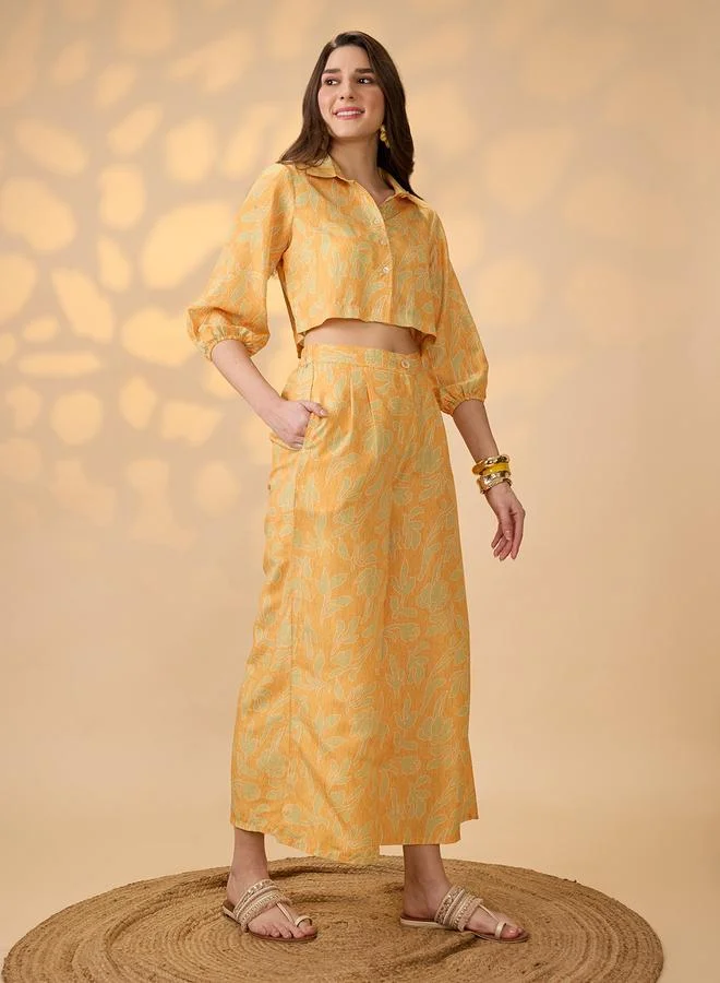 جلو باص طقم منسق من بلوزة قصيرة مطبع وبنطال بأرجل واسعة