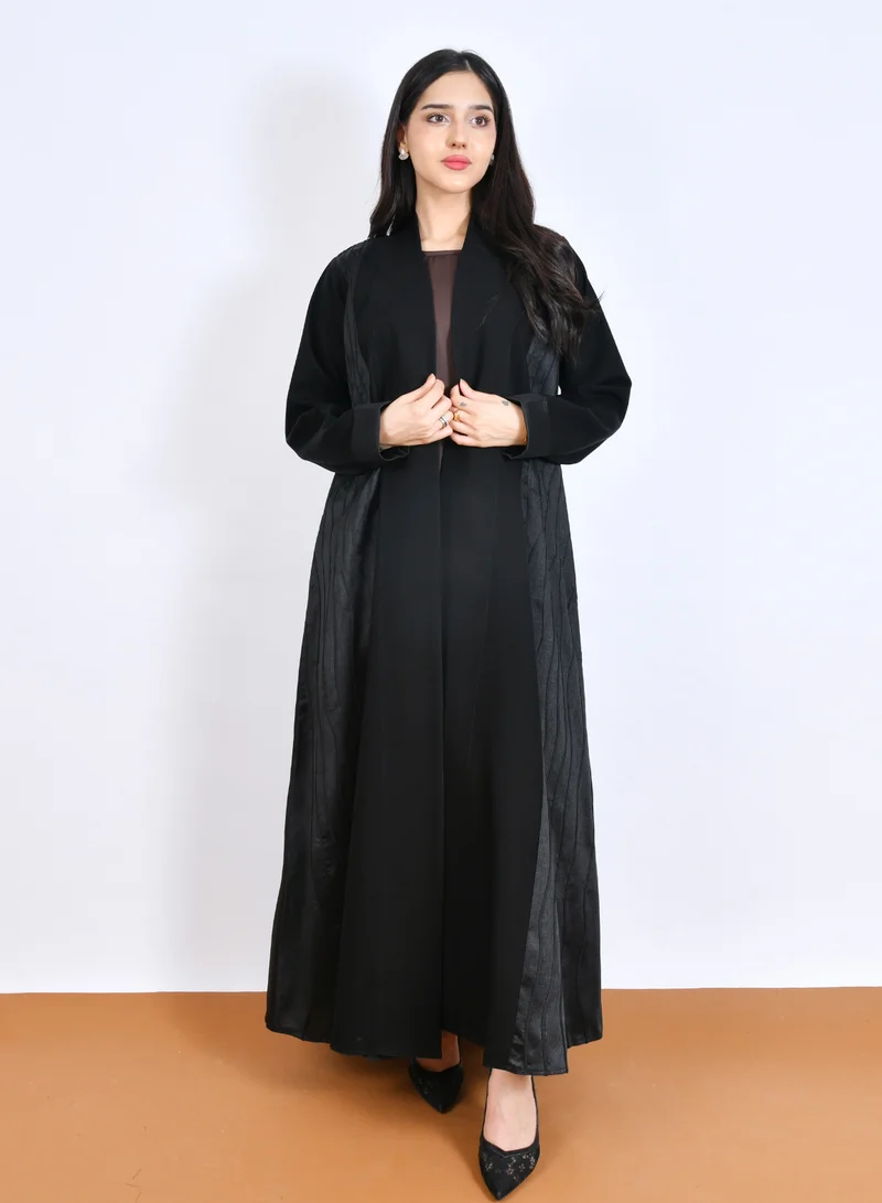 HAWRAA ABAYA Elegant black abaya with a half-flared design, featuring jacquard patterned fabric on the sides and sleeves.