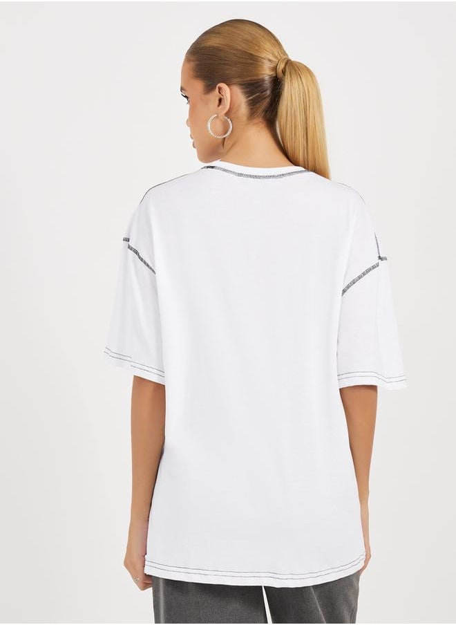 Styli - Oversized Slogan Print Round Neck T-Shirt with Contrast Stitch - Image 1